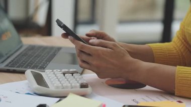 Akıllı telefon ve dizüstü bilgisayar kullanan genç kadın.