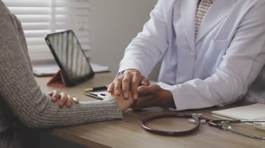 Doktor ve hasta ofiste masada oturuyorlar.