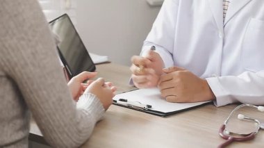 Yakın plan - bir hastanın elini tutan kadın doktor görüntüsü