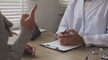 Erkek doktor hastayı elinde tutuyor.