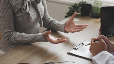 Beyaz önlüklü ve siyah ceketli genç doktor hastasında steteskop tutuyor. tıbbi konsept.