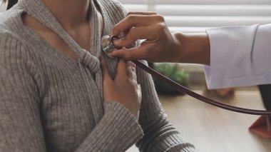 Doktor klinikteki genç kadının nabzını kontrol ediyor.