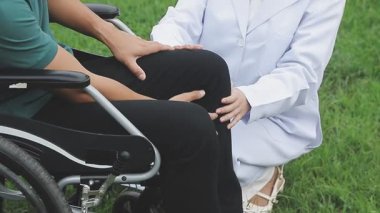 Tekerlekli sandalyede oturan genç kadın ve adam