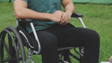 Parkta tekerlekli sandalyeli bir adam var.
