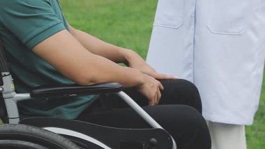 Tekerlekli sandalyeli genç Asyalı adam