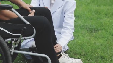 Beyaz tekerlekli sandalyedeki genç kadın engelli biriyle..