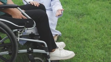 Bahçedeki tekerlekli sandalyedeki genç adam.