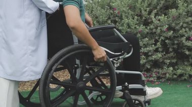 Koltuk değnekleriyle tekerlekli sandalyedeki engelli adam.