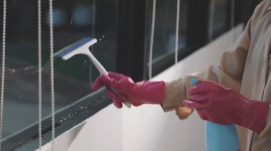 Ofisteki kadın penceresini temizliyor