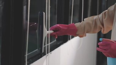 Koruyucu giysili işçi. Deterjan ile pencereyi temizliyor..