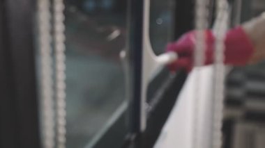 Kadın elektrikli süpürgeyle araba camlarını temizliyor.