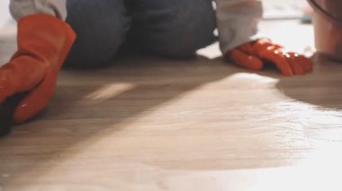 Yakın plan - kadın işçinin eve yeni ahşap parke döşemesi kurması.