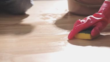 Kadın lastik eldivenle temizlik yapıyor.