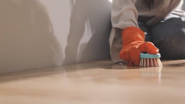 Kadın odada fırçayla tadilat yapıyor.