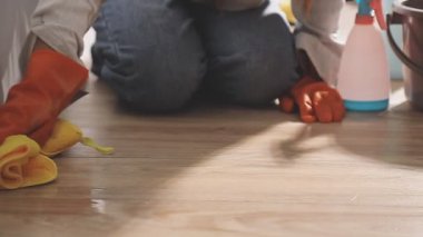 Eldivenli genç bir kadın mutfakta ev işi yapıyor.