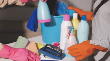 Lastik eldivenli kadın elinde bir şişe deterjan tutuyor..