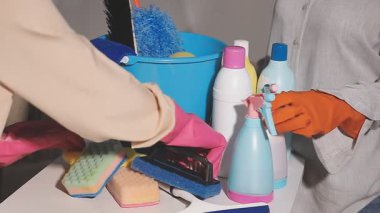 Bir adam mutfak odasında temizlik malzemesi tutuyor..