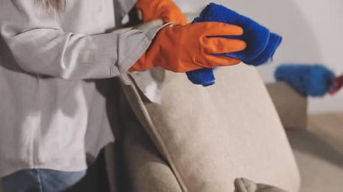 Kadın ellerini yeni bir kanepe ve elektrikli süpürgeyle kapat..