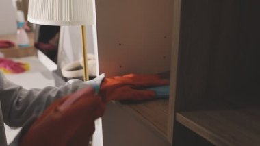 Beyaz gömlekli ve eldivenli kadın eve ahşap mobilya kuruyor.