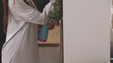 Kadın bahçıvan bahçesinde bir su bidonu ile bitkileri suluyor, bahçıvanlık ve tarım kavramı