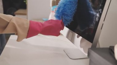 Eldivenli kadın eli banyoda fırça tutuyor.