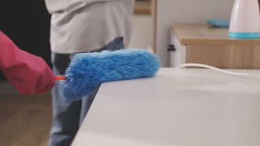 Odasında ahşap zeminde fırçası olan bir adam.