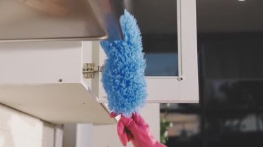 Mavi bir bezi temizleyen kadın.