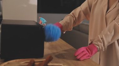 Mavi bir sünger ve bezle ellerini temizleyen bir kadın.