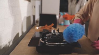 Elinde kahve makinesi olan ve mutfakta akıllı telefon kullanan bir kadının fotoğrafını çek.