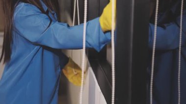 Mavi ceketli ve eldivenli işçi elinde metal bir çubuk tutuyor.