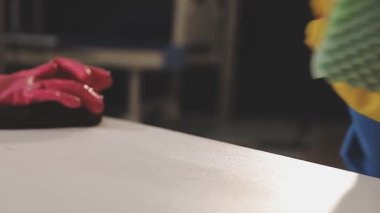 Eldiven giymiş bir işçi bir adamın ellerinde..