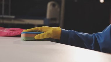Sarı eldivenli bir kadın mutfakta yerleri temizliyor. Temizlik konsepti