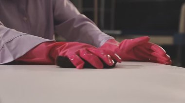 Kapalı - Pembe lastik eldiven tutan bir işçinin eli
