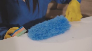 Evde bir bez parçasıyla masayı temizliyorum.