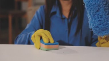 Mavi lastik eldivenli bir kadın temizlik yapıyor.