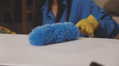 Masayı mavi süngerle temizleyen kadın.