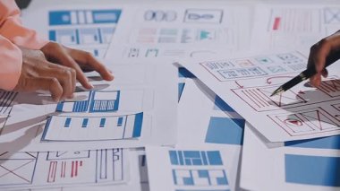 Ofiste çalışan tasarımcı planlar ve ofis kağıtları üzerine çizimler yapıyor.