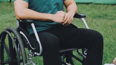 Tekerlekli sandalyede oturan engelli kadın.