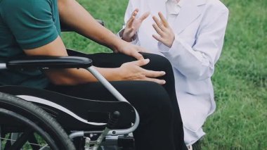 Doktor ve hemşire tekerlekli sandalyede oturuyor.