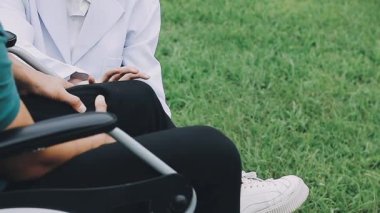 Parkta tekerlekli sandalyesi olan bir adam.