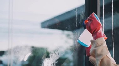 Pencereyi sprey ve paçavra ile temizliyorum.