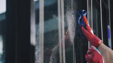 Kadın pencereyi paçavrayla temizliyor