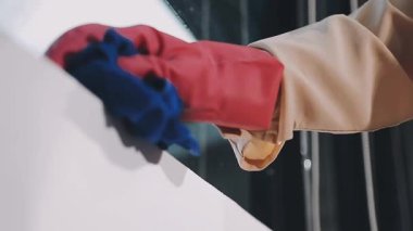 Bir odada penceresi olan koruyucu eldivenli bir işçi..