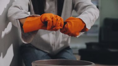 Beyaz boya fırçası ve fırçası olan siyah gömlekli bir adam.