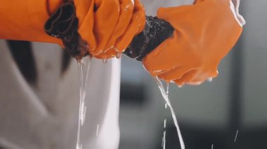 Yakın plan, bardağı suyla tutan bir elin fotoğrafı. Temizlik konsepti.