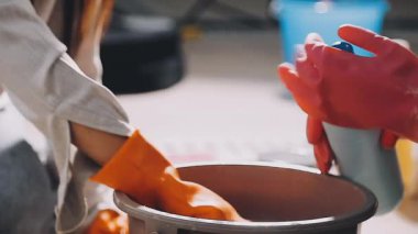 Kadın eli, kilden bir kap ve bir kase beyaz kil çömlek.