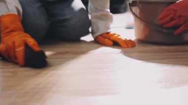 Boya silindiriyle döşeme boyası yapan adamın ellerini kapat.