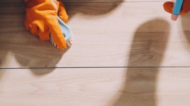 Elinde tahta bir tahtayla koruyucu eldivenler giymiş bir işçi.