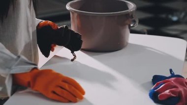 Önlüklü kadın ellerine yaklaş fırça ve fırçayla bir kase tut.