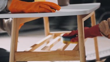 Ahşap zemini boyayan koruyucu eldivenler giyen işçi..